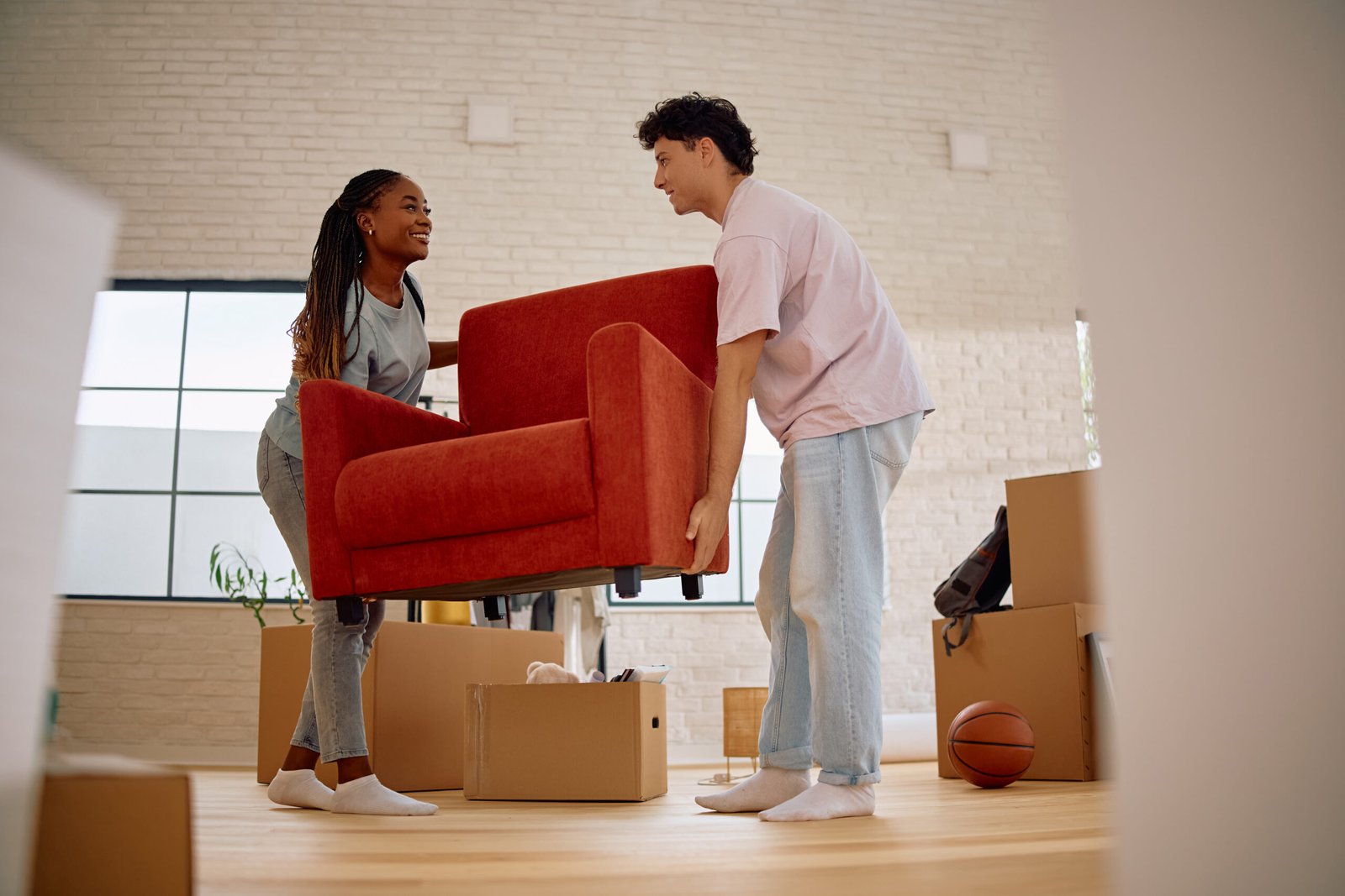 Couple moving furniture while preparing for professional vacate cleaning services in Perth