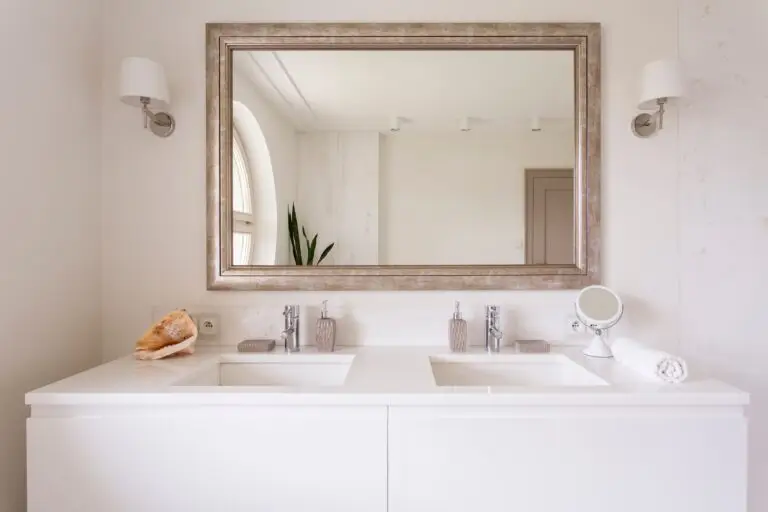 Bathroom with two sinks and a large mirror, showcasing spotless vanity countertops and polished chrome taps after thorough cleaning.